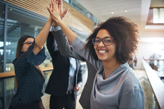 Smiling employees high five Smiling employees high five